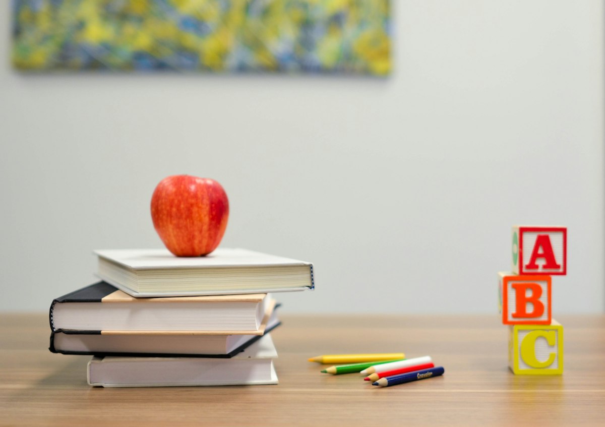 Schoolbooks, an apple and alphabet blocks on a desk